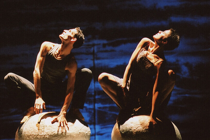 Zwei Menschen hockend mit Blick in den Himmel