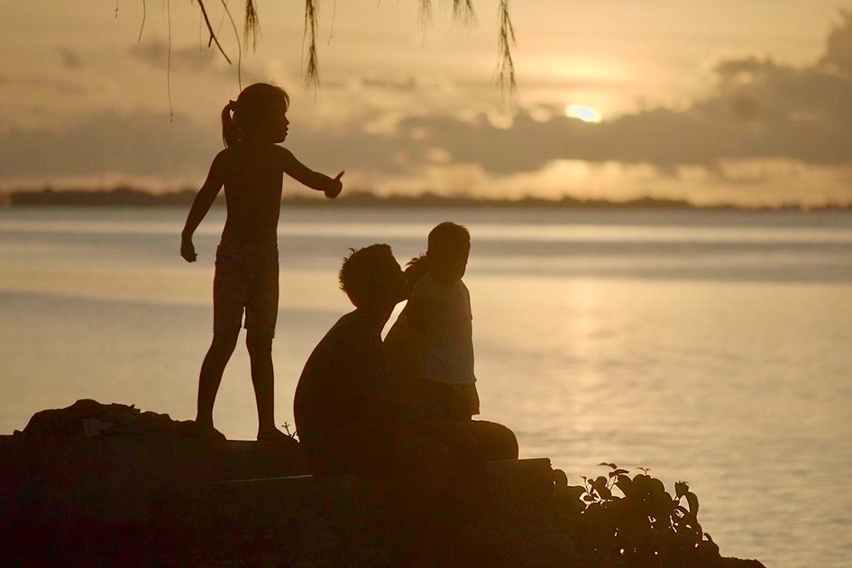 Drei Kinder im Sonnenuntergang am Strand